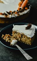 Close-up of a scrumptious homemade carrot cake slice topped with cream cheese frosting.